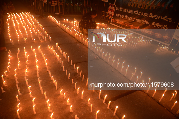 Former students of Ramkrishna Mission light candles as they take part in a protest to condemn the rape and murder of a young medic at RG Kar...