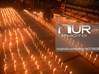 Former students of Ramkrishna Mission light candles as they take part in a protest to condemn the rape and murder of a young medic at RG Kar...