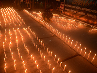 Former students of Ramkrishna Mission light candles as they take part in a protest to condemn the rape and murder of a young medic at RG Kar...