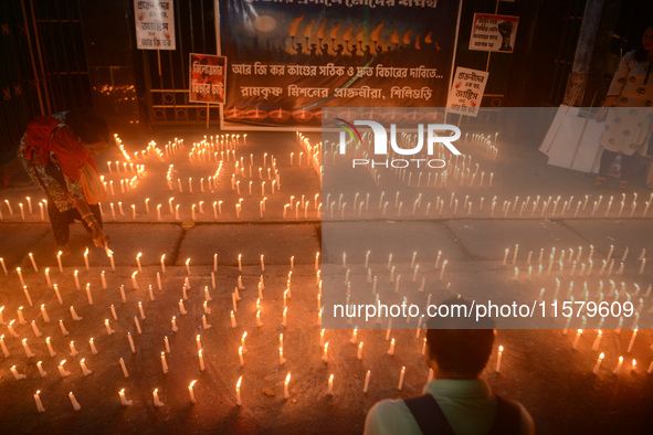 Former students of Ramkrishna Mission light candles as they take part in a protest to condemn the rape and murder of a young medic at RG Kar...