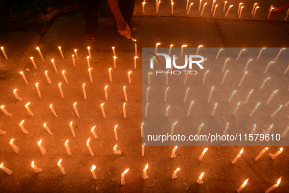 Former students of Ramkrishna Mission light candles as they take part in a protest to condemn the rape and murder of a young medic at RG Kar...