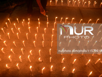 Former students of Ramkrishna Mission light candles as they take part in a protest to condemn the rape and murder of a young medic at RG Kar...