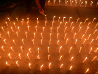 Former students of Ramkrishna Mission light candles as they take part in a protest to condemn the rape and murder of a young medic at RG Kar...