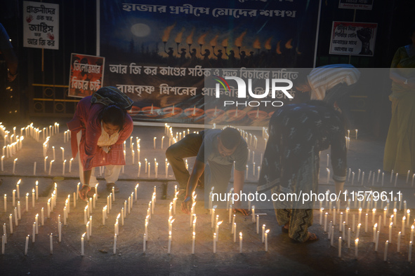 Former students of Ramkrishna Mission light candles as they take part in a protest to condemn the rape and murder of a young medic at RG Kar...