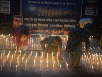 Former students of Ramkrishna Mission light candles as they take part in a protest to condemn the rape and murder of a young medic at RG Kar...