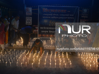 Former students of Ramkrishna Mission light candles as they take part in a protest to condemn the rape and murder of a young medic at RG Kar...