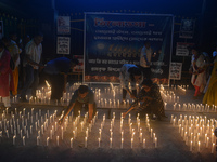 Former students of Ramkrishna Mission light candles as they take part in a protest to condemn the rape and murder of a young medic at RG Kar...