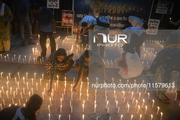 Former students of Ramkrishna Mission light candles as they take part in a protest to condemn the rape and murder of a young medic at RG Kar...