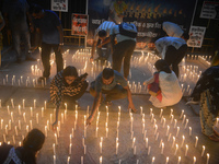 Former students of Ramkrishna Mission light candles as they take part in a protest to condemn the rape and murder of a young medic at RG Kar...