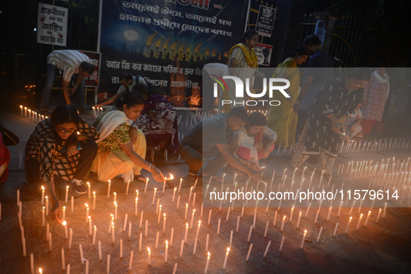 Former students of Ramkrishna Mission light candles as they take part in a protest to condemn the rape and murder of a young medic at RG Kar...