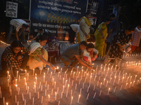 Former students of Ramkrishna Mission light candles as they take part in a protest to condemn the rape and murder of a young medic at RG Kar...