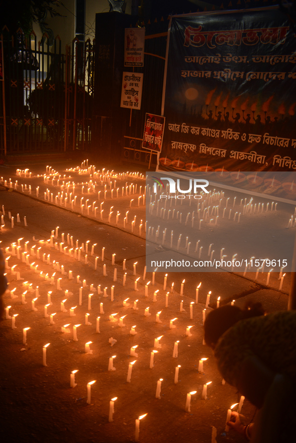 Former students of Ramkrishna Mission light candles as they take part in a protest to condemn the rape and murder of a young medic at RG Kar...