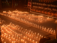 Former students of Ramkrishna Mission light candles as they take part in a protest to condemn the rape and murder of a young medic at RG Kar...