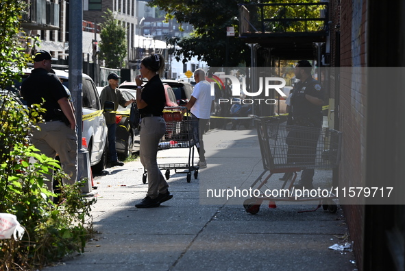 NYPD crime scene investigators search for evidence where a 32-year-old man is shot numerous times and killed in Manhattan, New York, United...