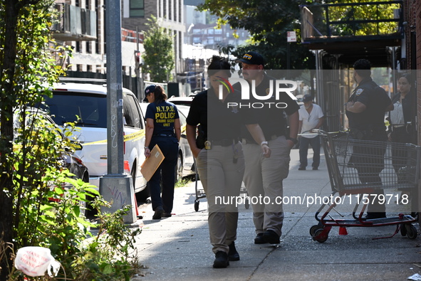 NYPD crime scene investigators search for evidence where a 32-year-old man is shot numerous times and killed in Manhattan, New York, United...