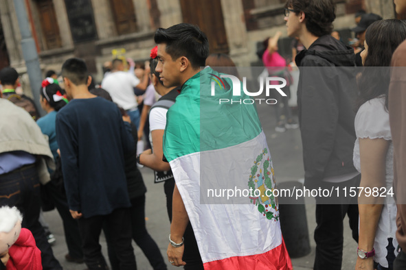 A person wears a Mexican flag on their back while attending the celebration of the 214th Anniversary of Mexico's Independence Day in the mai...