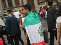 A person wears a Mexican flag on their back while attending the celebration of the 214th Anniversary of Mexico's Independence Day in the mai...