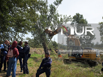 The driver of the excavator pushes a tree and tears it off. After months of negotiations and pressures from NGE/Atosca, and two attacks by i...