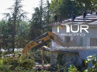 The excavator destroys the balcony of the 'Verger' house even though people stand on the roof of the house. After months of negotiations and...