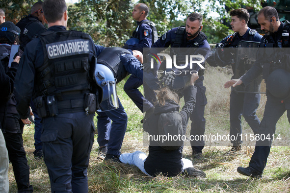 A Zadiste is pushed away by Gendarmes. After months of negotiations and pressures from NGE/Atosca, and two incendiary attacks, Alexandra, th...