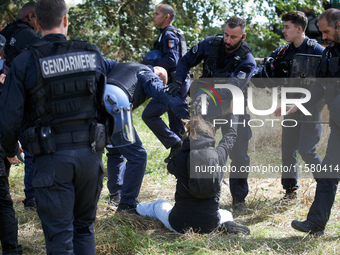 A Zadiste is pushed away by Gendarmes. After months of negotiations and pressures from NGE/Atosca, and two incendiary attacks, Alexandra, th...