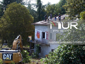 The excavator operates near the house of the 'Verger'. He works very close to the houses even if there are people on the roof. After months...