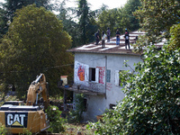 The excavator operates near the house of the 'Verger'. He works very close to the houses even if there are people on the roof. After months...