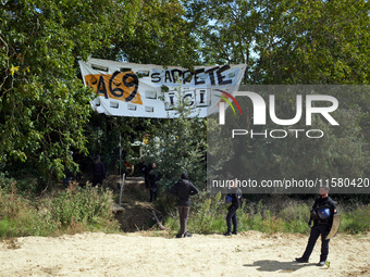 Gendarmes stand guard near the 'Verger' ZAD. The banner reads 'A69, the highway stops there'. After months of negotiations and pressures fro...