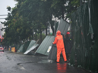 Workers clean up after a fence is blown down at a construction site in Nanjing, Jiangsu province, China, on September 17, 2024. (