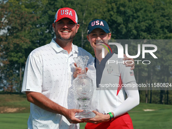 GAINESVILLE, VIRGINIA - SEPTEMBER 15: Nelly Korda of the United States poses with her caddie while holding the trophy after a Team USA win a...