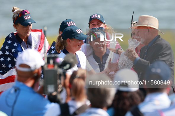 GAINESVILLE, VIRGINIA - SEPTEMBER 15: John Solheim representing the Solheim family presents Staycy Lewis of the United States with the troph...