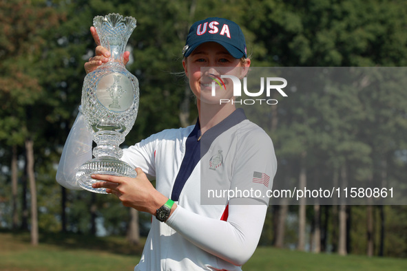 GAINESVILLE, VIRGINIA - SEPTEMBER 15: Nelly Korda of the United States poses with her caddie while holding the trophy after a Team USA win a...