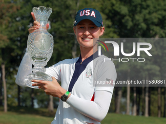 GAINESVILLE, VIRGINIA - SEPTEMBER 15: Nelly Korda of the United States poses with her caddie while holding the trophy after a Team USA win a...