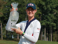 GAINESVILLE, VIRGINIA - SEPTEMBER 15: Nelly Korda of the United States poses with her caddie while holding the trophy after a Team USA win a...