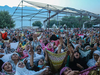 Muslim devotees react as a priest displays a relic believed to be a hair from the beard of Islam's Prophet Muhammad during a gathering organ...