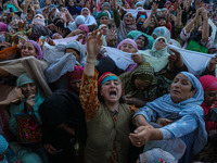 Muslim devotees react as a priest displays a relic believed to be a hair from the beard of Islam's Prophet Muhammad during a gathering organ...