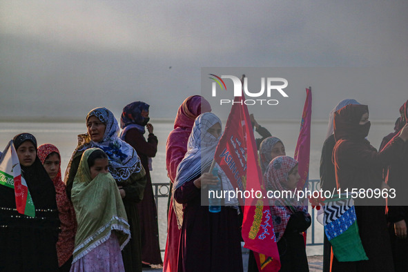 Kashmiri Muslim women watch a rally on the occasion of Eid Milad-un-Nabi, also known as Mawlid, which marks the birth anniversary of the Pro...