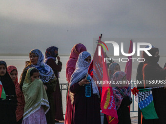 Kashmiri Muslim women watch a rally on the occasion of Eid Milad-un-Nabi, also known as Mawlid, which marks the birth anniversary of the Pro...