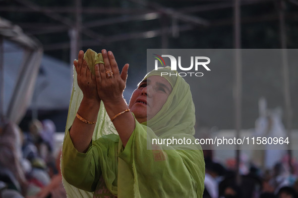 A Kashmiri Muslim devotee prays as a priest displays a relic believed to be a hair from the beard of Islam's Prophet Muhammad during a gathe...