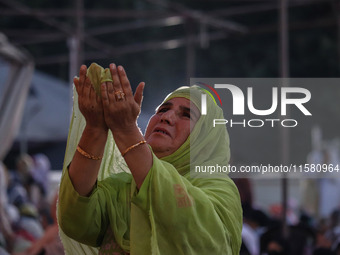 A Kashmiri Muslim devotee prays as a priest displays a relic believed to be a hair from the beard of Islam's Prophet Muhammad during a gathe...