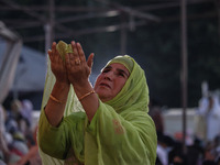 A Kashmiri Muslim devotee prays as a priest displays a relic believed to be a hair from the beard of Islam's Prophet Muhammad during a gathe...