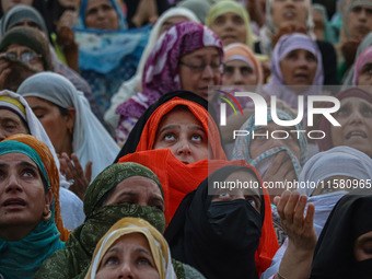 Muslim devotees react as a priest displays a relic believed to be a hair from the beard of Islam's Prophet Muhammad during a gathering organ...