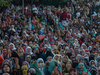 Muslim devotees react as a priest displays a relic believed to be a hair from the beard of Islam's Prophet Muhammad during a gathering organ...