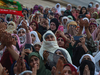 Muslim devotees react as a priest displays a relic believed to be a hair from the beard of Islam's Prophet Muhammad during a gathering organ...