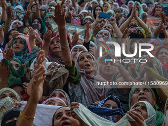 Muslim devotees react as a priest displays a relic believed to be a hair from the beard of Islam's Prophet Muhammad during a gathering organ...