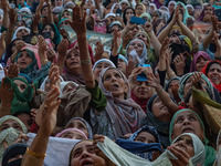 Muslim devotees react as a priest displays a relic believed to be a hair from the beard of Islam's Prophet Muhammad during a gathering organ...