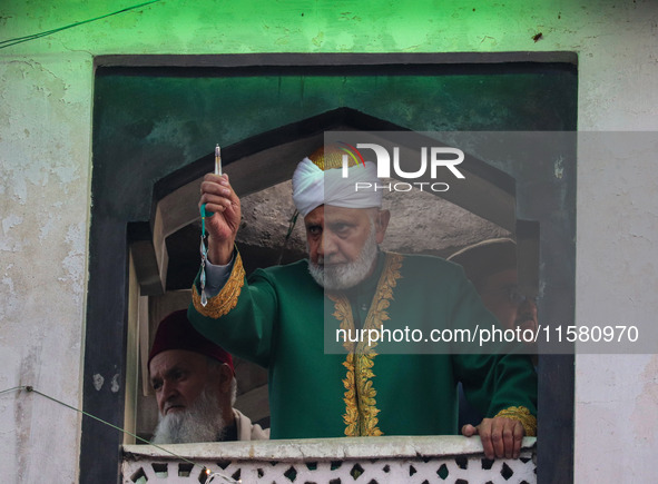 A Muslim cleric displays a relic believed to be a hair from the beard of Islam's Prophet Muhammad during a gathering organized on the occasi...