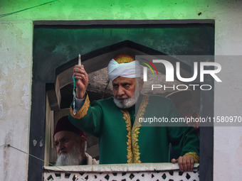 A Muslim cleric displays a relic believed to be a hair from the beard of Islam's Prophet Muhammad during a gathering organized on the occasi...