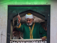 A Muslim cleric displays a relic believed to be a hair from the beard of Islam's Prophet Muhammad during a gathering organized on the occasi...