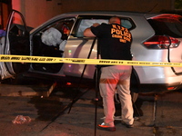 Crime scene investigators collect evidence, mark evidence with evidence markers, and inspect the vehicle airbag with blood on it from the vi...